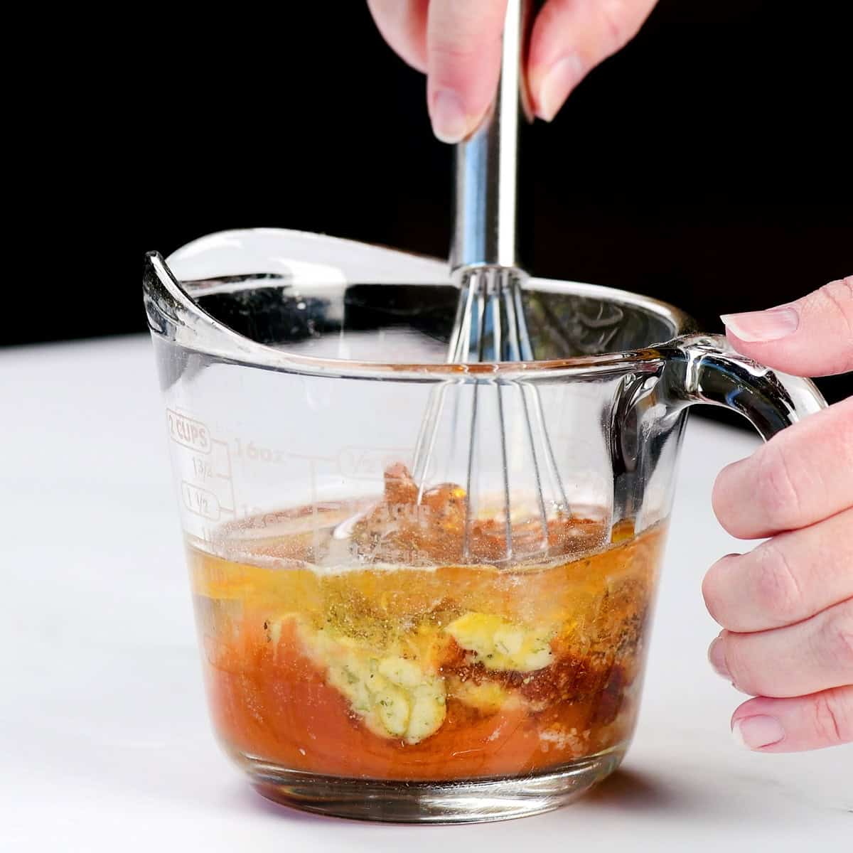 Stirring ingredients in a small glass measuring cup.